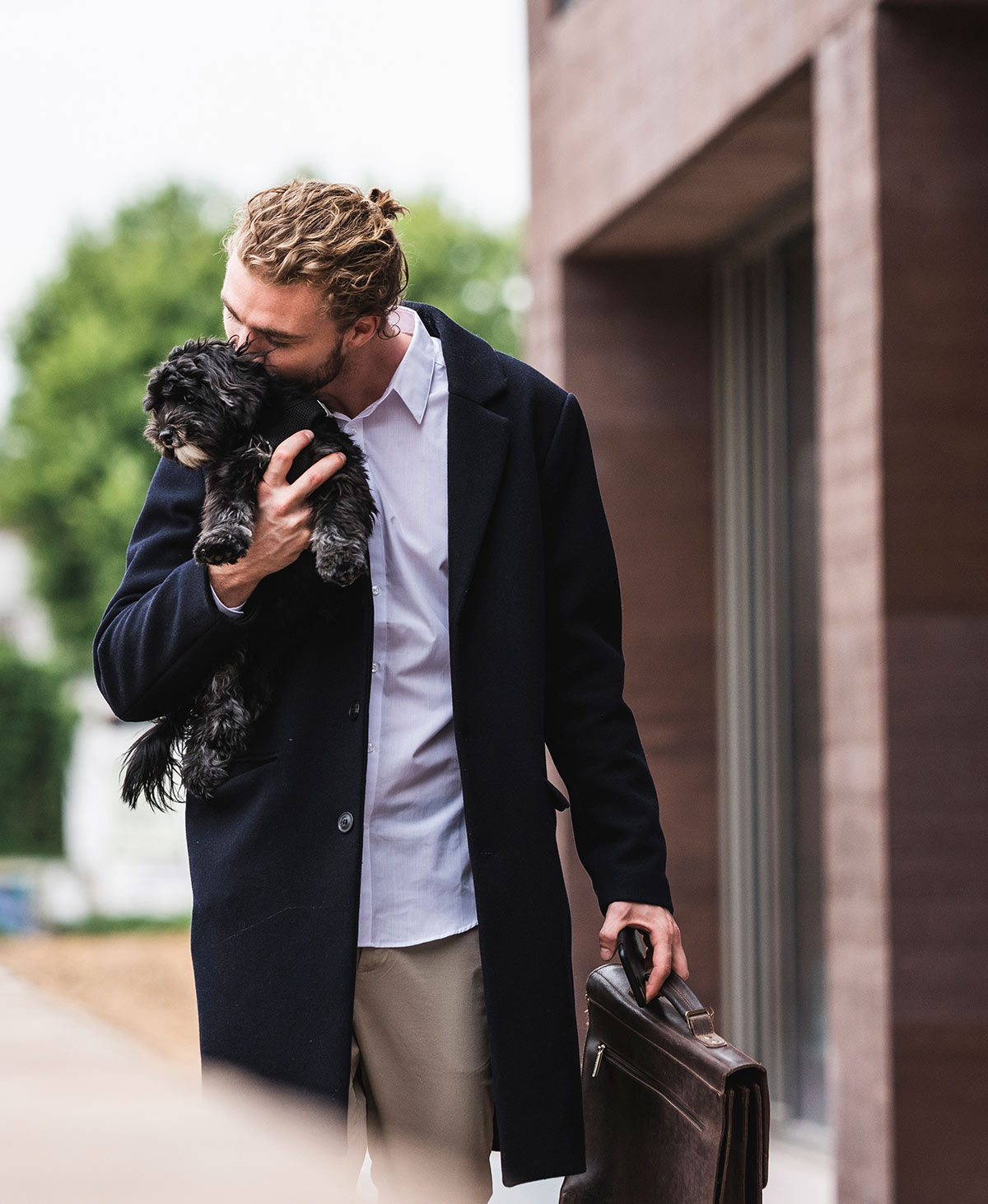 Man with dog in front of commercial building
